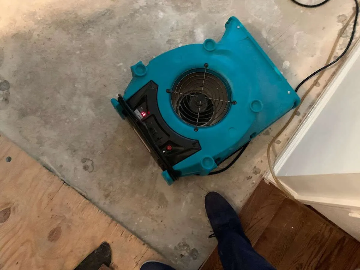Air mover drying subfloor during Leak Detection & Repair in Granville